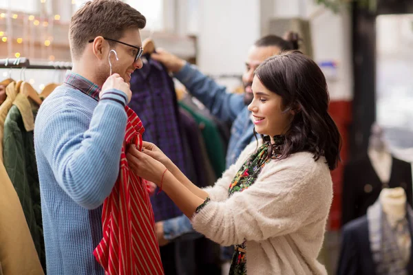 Pareja eligiendo ropa en tienda de ropa vintage — Foto de Stock