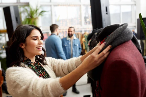 Счастливая женщина выбирает одежду в магазине одежды — стоковое фото