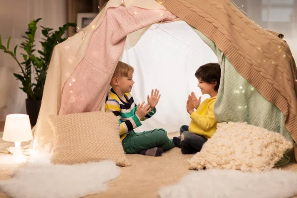 Мальчики играют в аплодисменты в детской палатке дома — стоковое фото