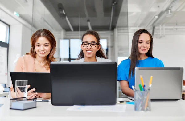 Mulheres de negócios com tablet pc e laptops no escritório — Fotografia de Stock