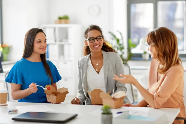 Happy businesswomen eating take out food at office — Stock Photo, Image