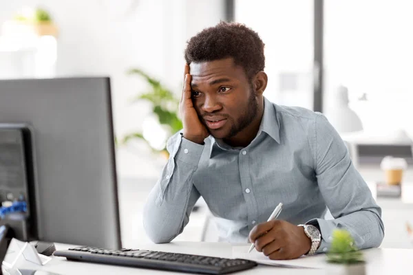 Zakenman met computer en papieren op kantoor — Stockfoto