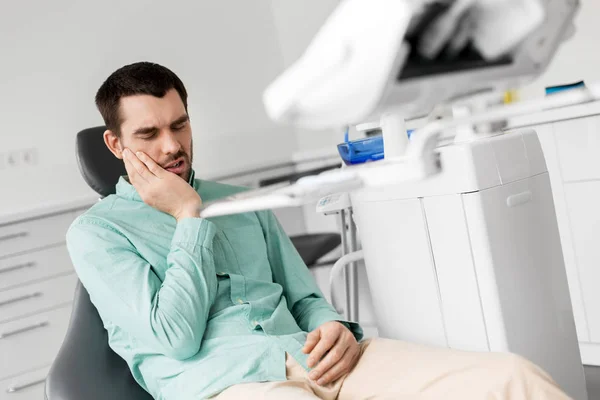 Paciente que tiene dolor de muelas en el consultorio dental —  Fotos de Stock