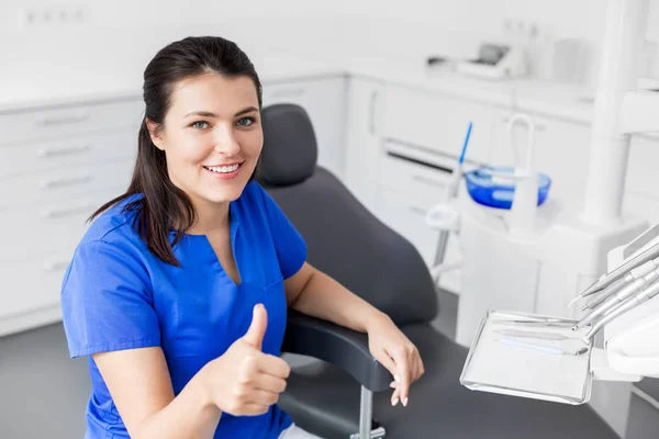 Dentista na clínica dentária mostrando polegares para cima Fotos De Bancos De Imagens