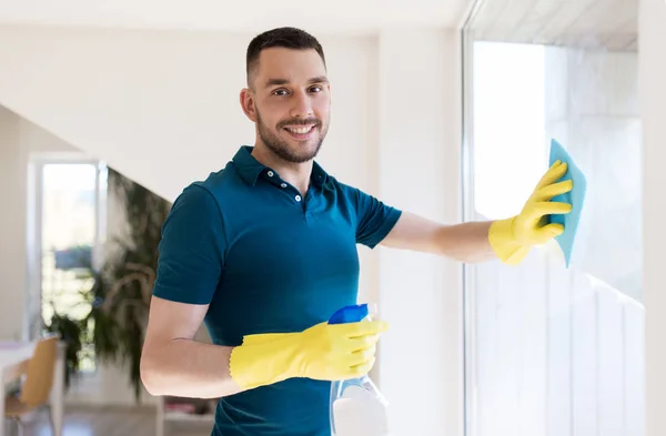 Man in rubber gloves cleaning window with rag — Stock Photo, Image