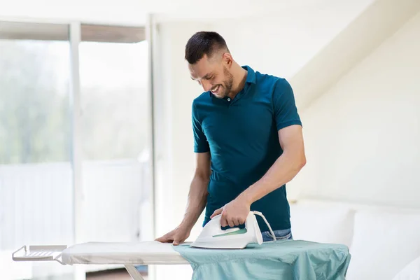 Hombre planchando camisa por plancha en casa — Foto de Stock