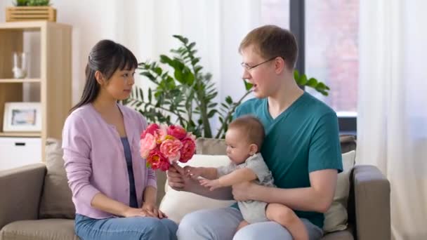 Famille heureuse avec des fleurs et bébé garçon à la maison — Video