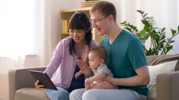 Счастливая семья с ребенком и планшетным компьютером дома — стоковое видео