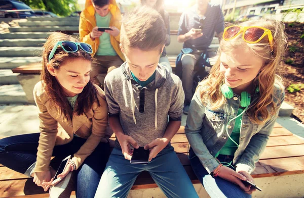Gelukkig jeugdvrienden met smartphones outdoors — Stockfoto