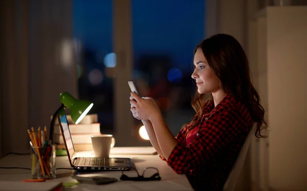Étudiante femme avec ordinateur portable et smartphone à la maison — Photo