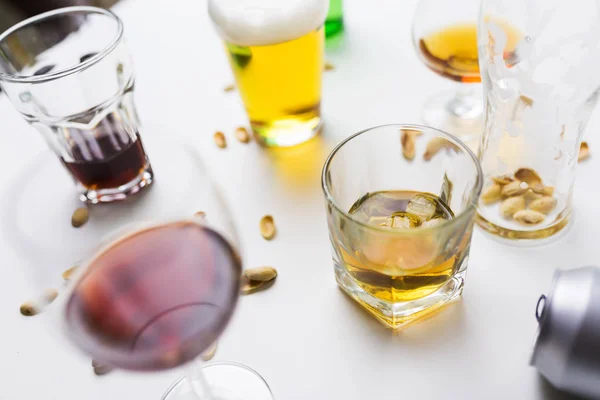 Gläser mit verschiedenen alkoholischen Getränken auf unordentlichem Tisch — Stockfoto