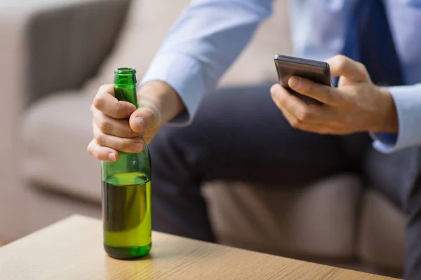 Primer plano del hombre con teléfono inteligente y botella de cerveza — Foto de Stock