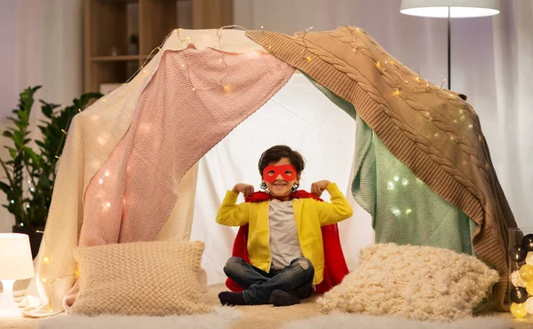 Lycklig pojke i super hjälte grejer i barn tält hemma — Stockfoto