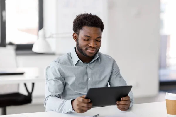 Homem de negócios sorridente com tablet pc no escritório — Fotografia de Stock