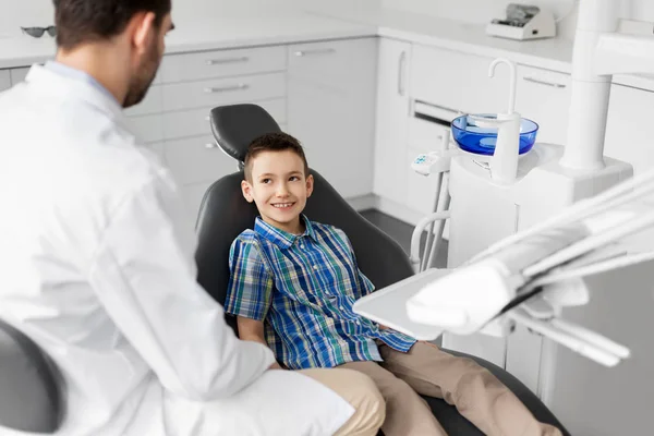 Dentista hablando con niño paciente en clínica dental —  Fotos de Stock