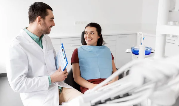 Dentista falando com paciente do sexo feminino na clínica odontológica — Fotografia de Stock