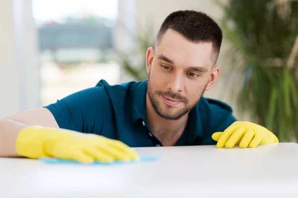 Man cleaning table with cloth at home — Stock Photo, Image