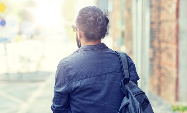 Man with backpack walking along city street — Stock Photo, Image