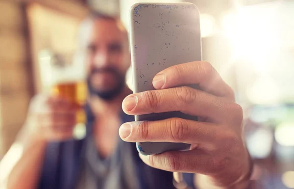 Close up de homem com smartphone e cerveja no pub — Fotografia de Stock