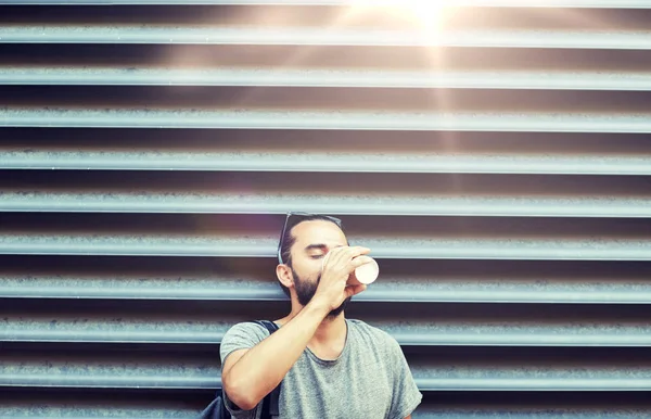 Člověk pije kávu z papírového kelímku na ulici — Stock fotografie