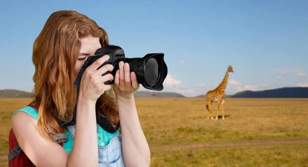 Mulher com mochila e câmera sobre savana — Fotografia de Stock