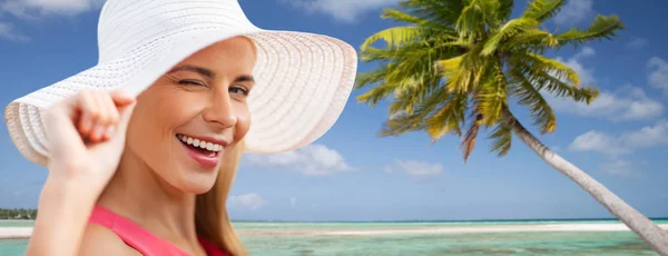 Beautiful smiling woman in sun hat on beach — Stock Photo, Image