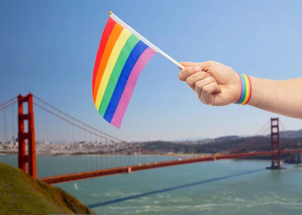 Mano con orgullo gay arco iris bandera y pulsera — Foto de Stock