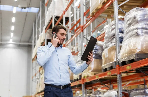 Empresário chamando no smartphone no armazém — Fotografia de Stock