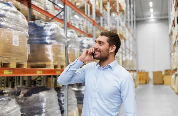 Businessman calling on smartphone at warehouse — Stock Photo, Image