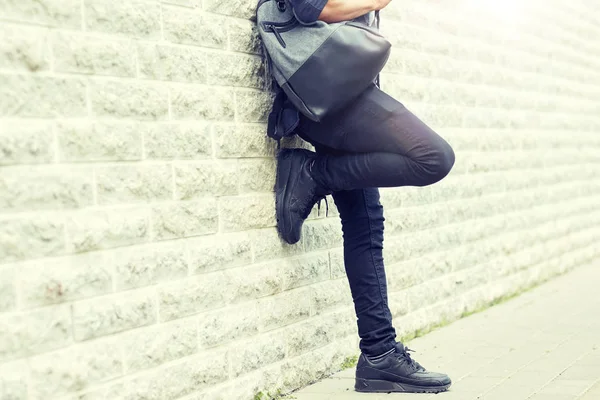 Крупным планом человек с рюкзаком стоит у стены — стоковое фото