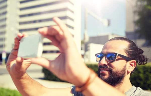 Hombre tomando vídeo o selfie por teléfono inteligente en la ciudad — Foto de Stock