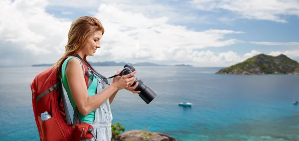 Жінка з рюкзаком і камерою над пляжем — стокове фото