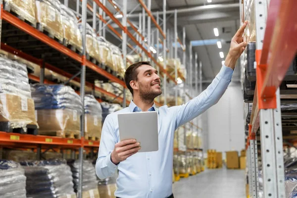 Glücklicher Geschäftsmann mit Tablet-PC im Lager — Stockfoto