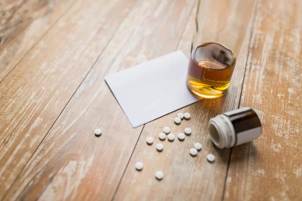 Flasche Alkohol und Tabletten auf dem Tisch — Stockfoto