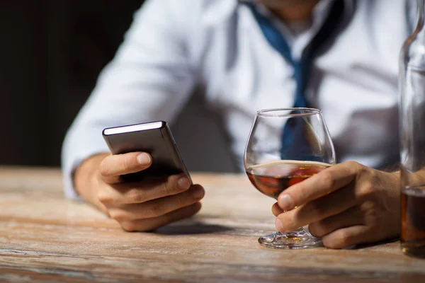 Закрыть человека со смартфоном и алкоголем — стоковое фото