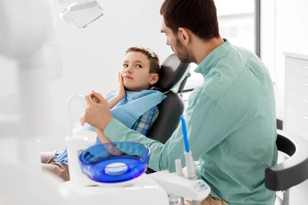 Батько підтримує сина в стоматологічній клініці — стокове фото