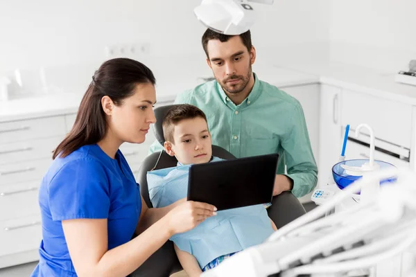 Стоматолог показывает планшет ребенку в стоматологической клинике — стоковое фото
