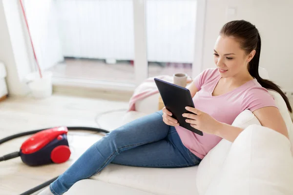 Frau mit Tablet-PC und Staubsauger zu Hause — Stockfoto