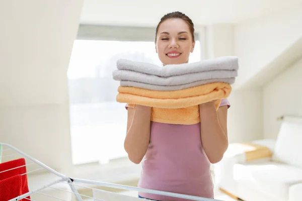 Женщина с полотенцами и сушилкой дома — стоковое фото