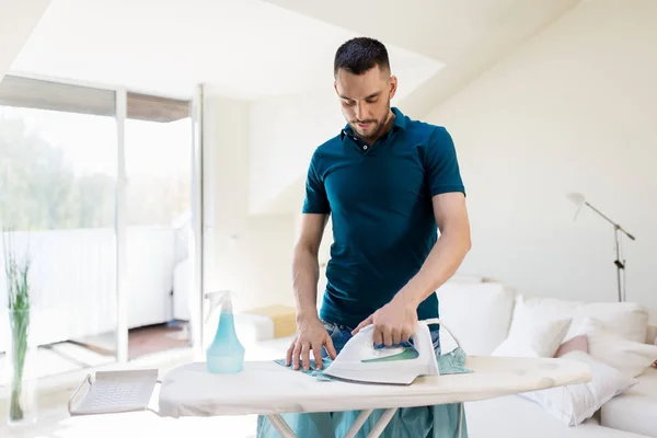 Hombre planchando camisa por plancha en casa — Foto de Stock