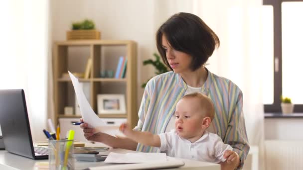 スマート フォンで呼び出すの赤ちゃんと一緒に働く母親 — ストック動画