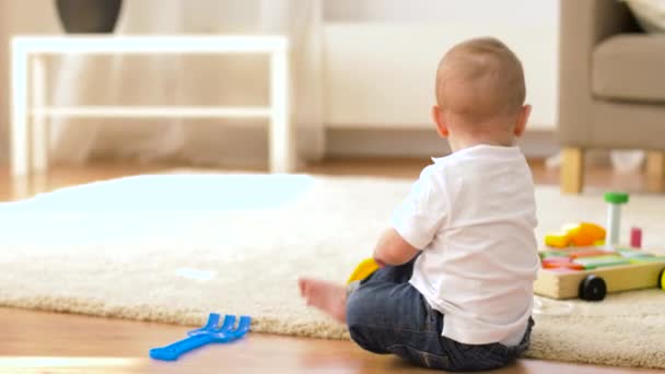 Küçük bebek evde oyuncaklarla oynuyor. — Stok video