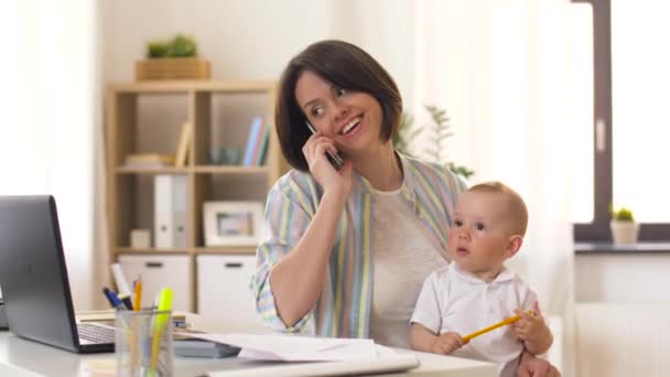Работающая мать с ребенком звонит на смартфон — стоковое видео