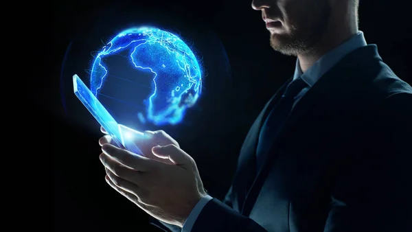 Homem de negócios com tablet pc e holograma de terra — Fotografia de Stock