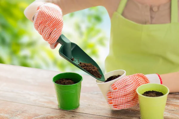 Close up of woman hands with trowel adding soil — Stock Photo, Image