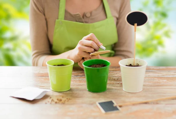 Close up van vrouw schrijven op tuin naamplaatje — Stockfoto