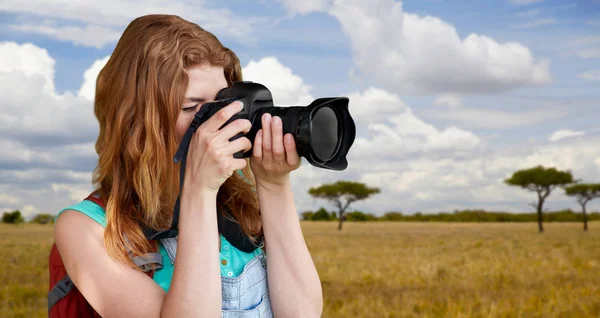 Mulher com mochila e câmera sobre savana — Fotografia de Stock