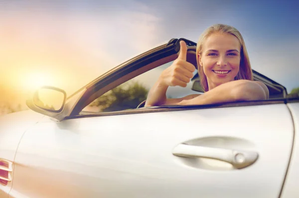 Feliz jovem mulher no conversível carro polegares para cima — Fotografia de Stock