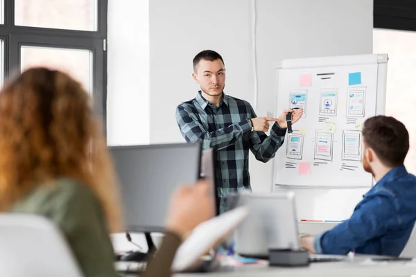 Hombre mostrando reloj inteligente al equipo creativo en la oficina —  Fotos de Stock