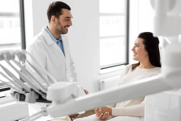 Dentista hablando con paciente femenina en clínica dental —  Fotos de Stock